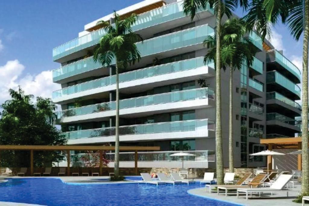 阿拉亚尔-杜卡布lebon vivant arraial do Cabo praia grande的一座带游泳池和棕榈树的建筑的图像
