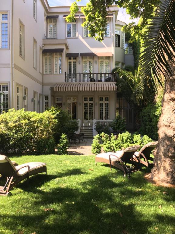 圣地亚哥玛迪尔达斯精品酒店的坐在建筑物前面的草上一组椅子
