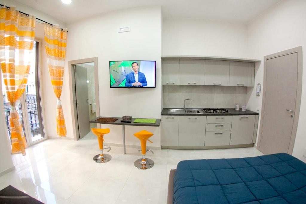 那不勒斯Casa del Sol的厨房配有一张床,墙上配有电视。