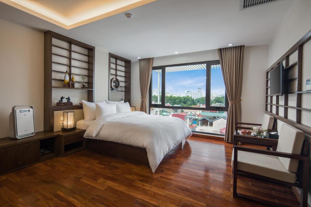 河内布兰迪富士酒店的一间卧室设有一张床和一个大窗户