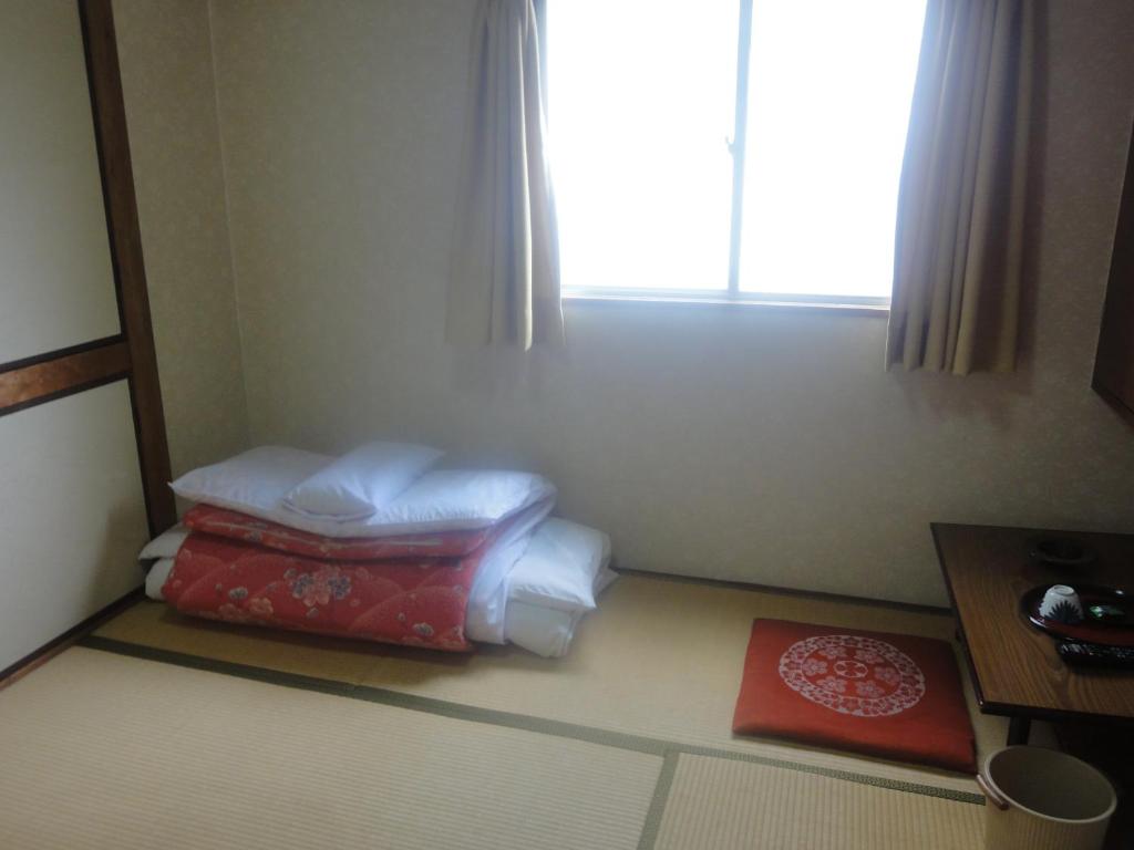 广岛天龙日式旅馆的配有枕头和窗户的房间