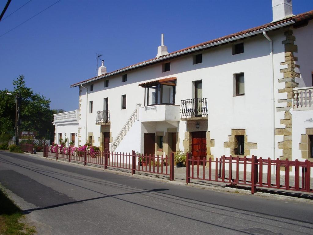 圣塞瓦斯蒂安伊图里科所兰德科萨酒店的街上有红墙的白色房子