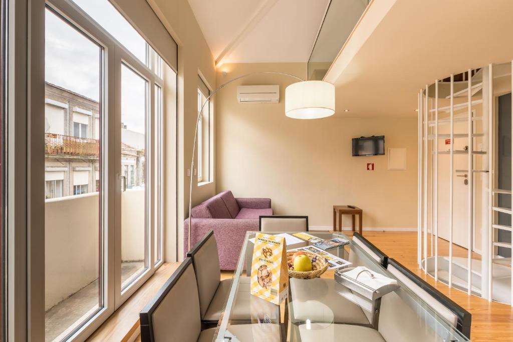 波尔图PATH Porto Apartments的客厅配有玻璃桌和紫色沙发