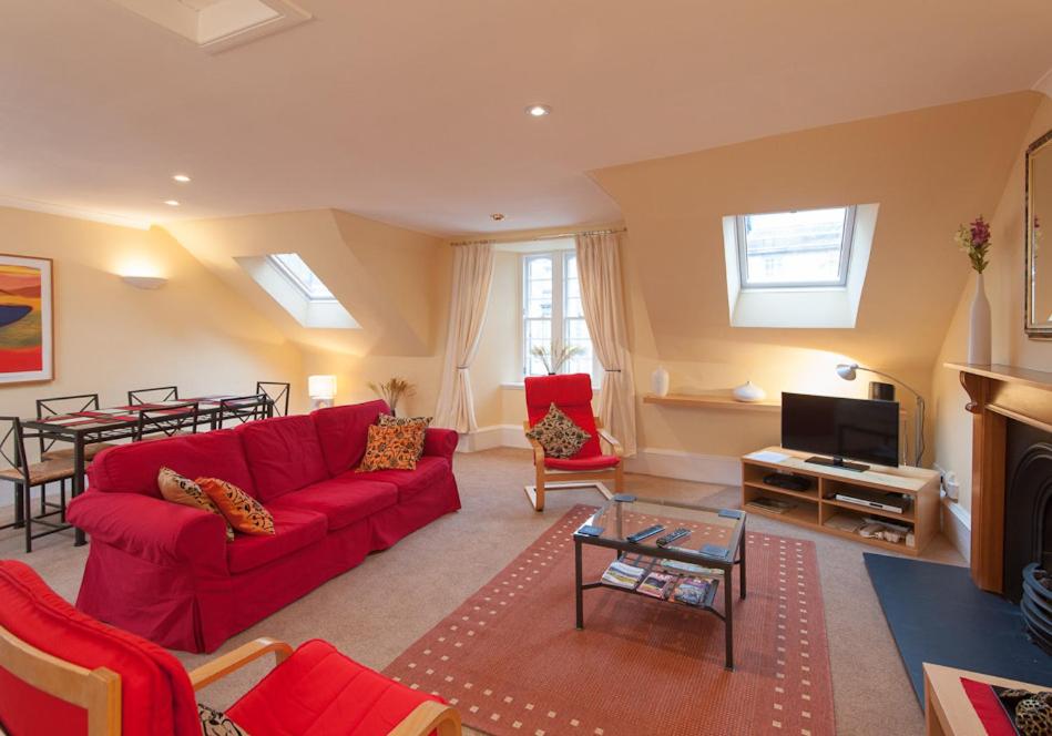 爱丁堡Parliament Sq (apt 5) Royal mile的客厅配有红色的沙发和桌子