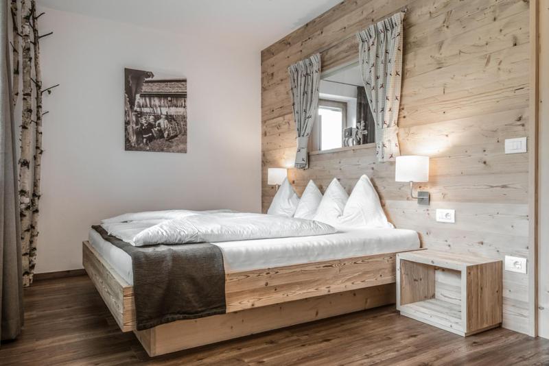 圣洛伦佐-迪塞巴托Haus Spielbichl的一间卧室设有一张带木墙的大床