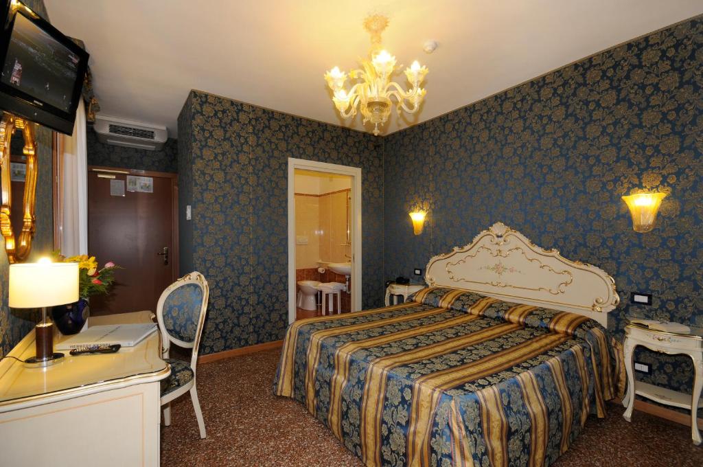 威尼斯威尼斯商人酒店的酒店客房,配有床和电视