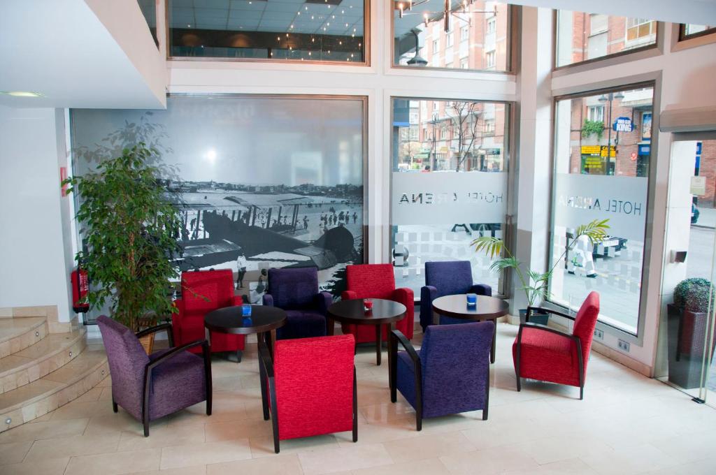 希洪阿伦纳酒店的餐厅设有红色和蓝色的椅子和桌子