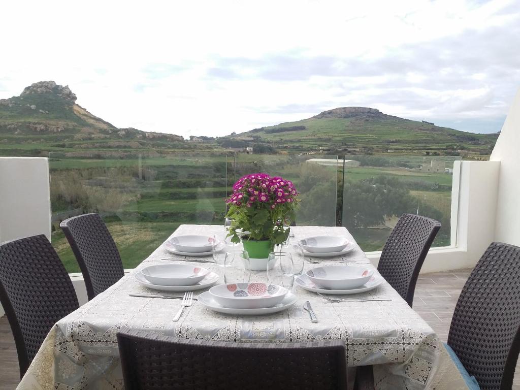 QbajjarPenthouse view的一张桌子,上面有盘子和玻璃杯,花瓶