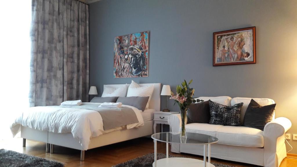 莱比锡Apartment MUSIKVIERTEL的卧室配有白色的床和沙发
