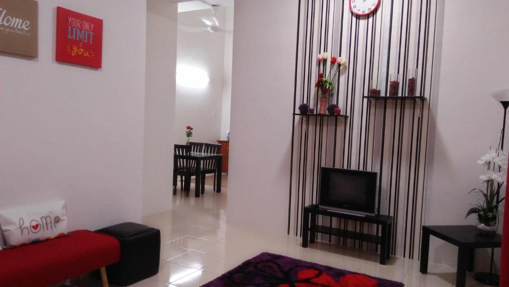 斯里伊斯兰德斯里依斯干达迈民宿的客厅配有红色沙发和电视