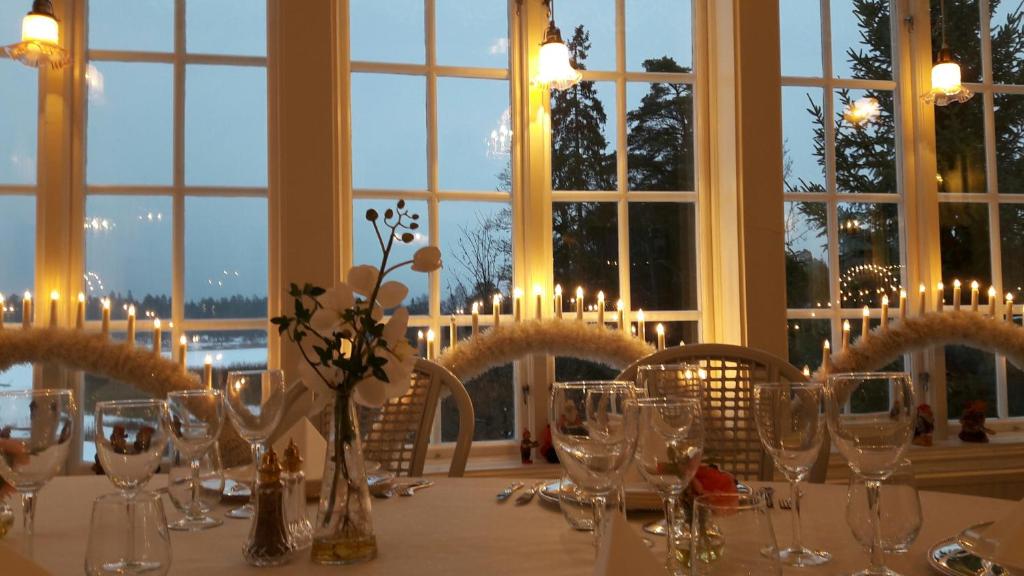 MarielundOdalgården Hotell, Kurs & Konferens的窗户客房内的桌子上摆放着玻璃杯和鲜花
