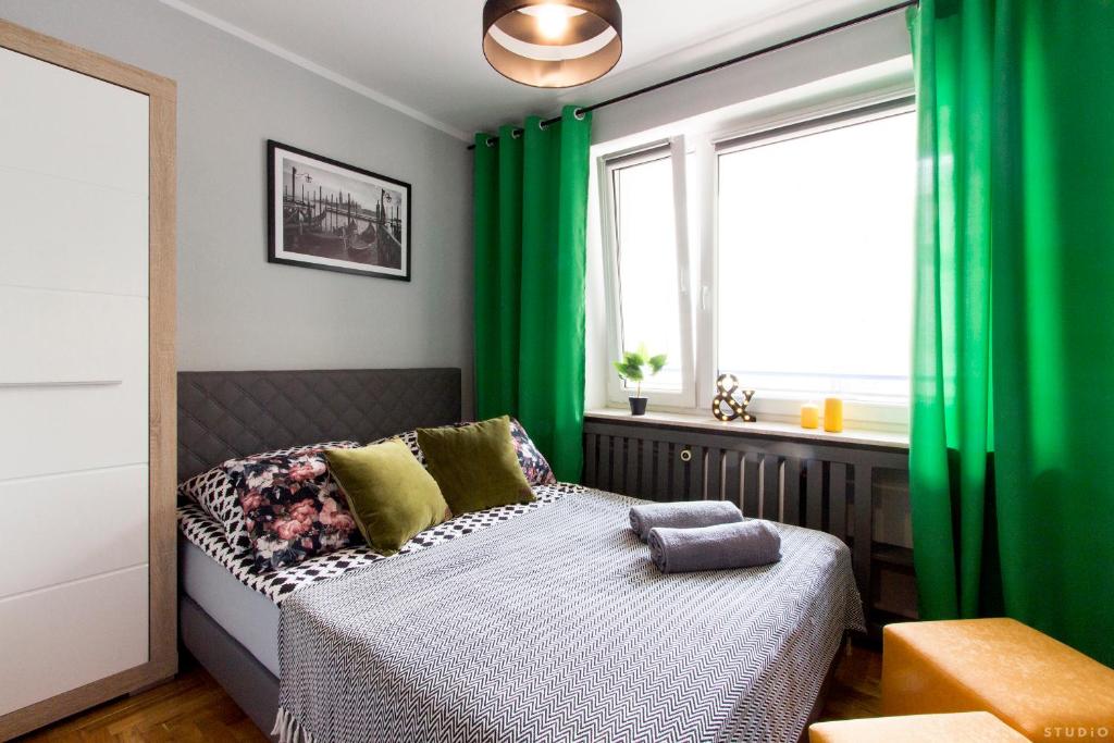 华沙ClickTheFlat Hoża Street Apart Rooms的一间卧室配有绿色窗帘和一张带窗户的床