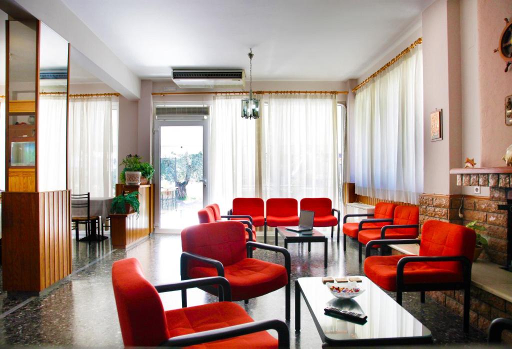 卡梅纳维洛拉Noufara Hotel的一间设有红色椅子和桌子的等候室