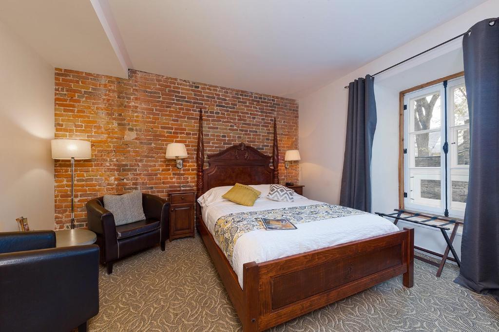 魁北克市家乐德布瓦旅馆的一间卧室设有一张床和砖墙