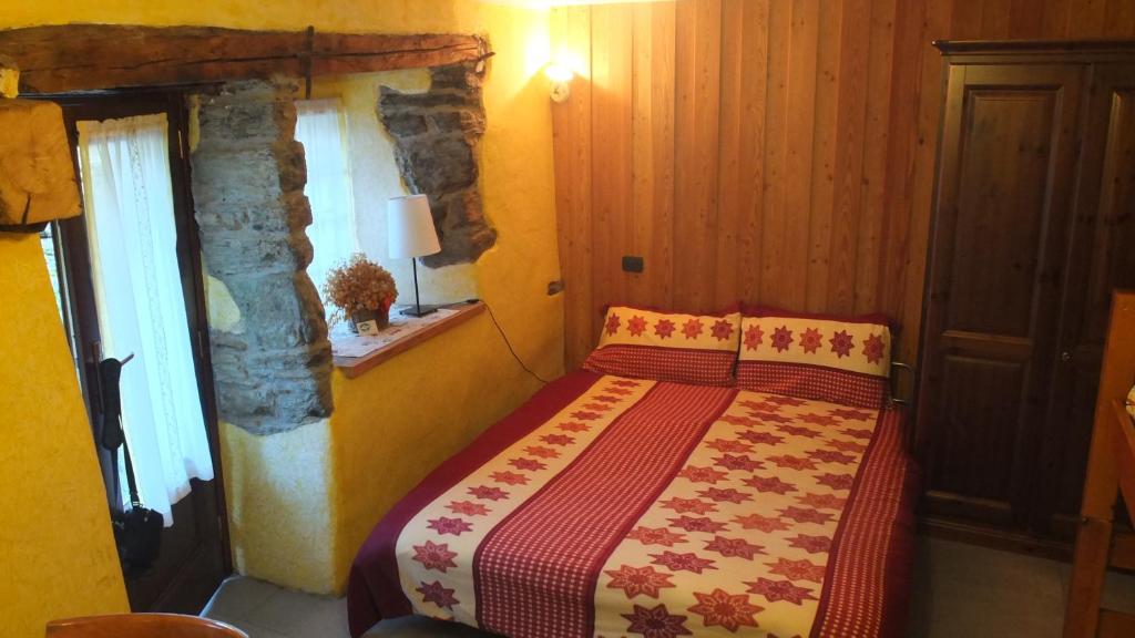 DouesMaison de la Place的一间卧室配有一张带红色和黄色毯子的床