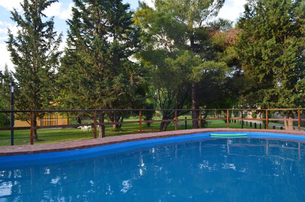 圣拉斐尔Posada del Viajero San Rafael的绿树成荫的公园里的一个蓝色游泳池