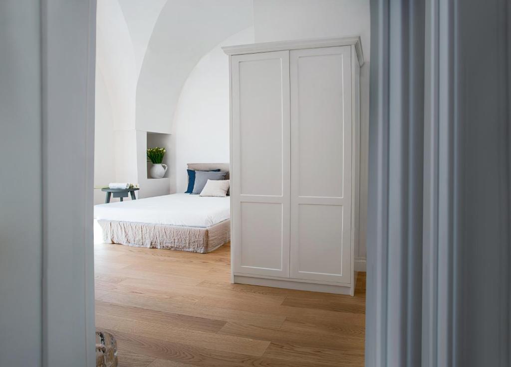 奥里亚Casa Vacanze Torre Palomba的一间白色卧室,配有床和白色门