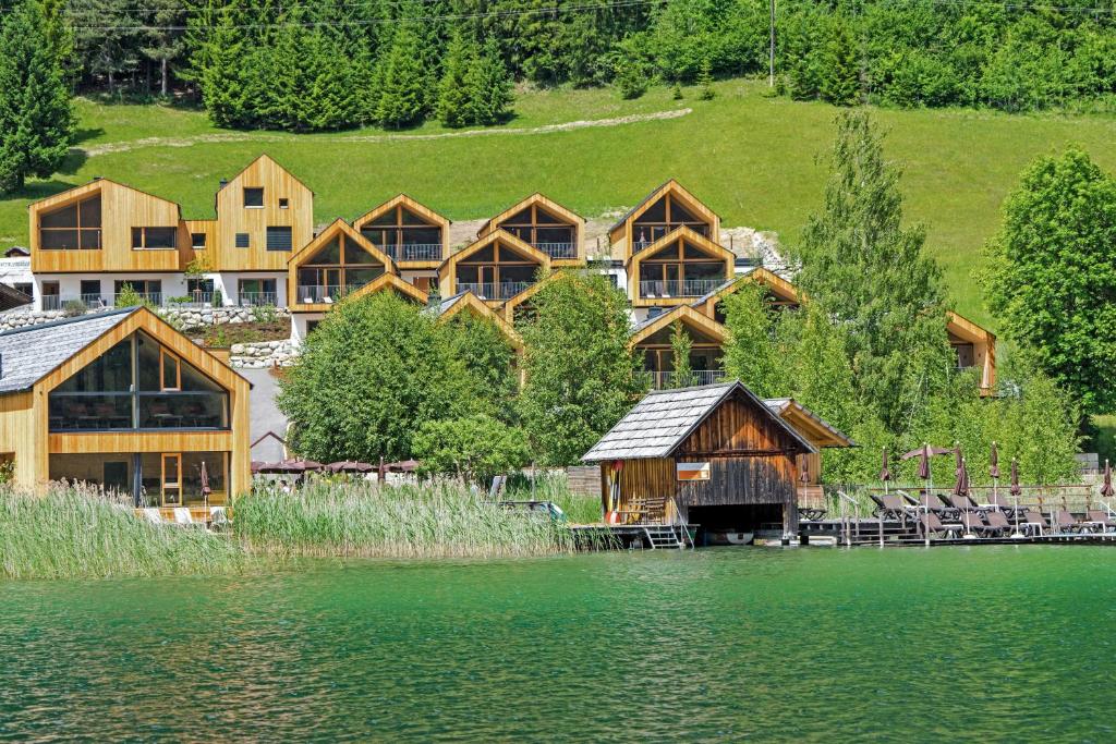 魏森湖Regitnig - 4 Sterne Hotel und Chalets的湖畔的一组木屋