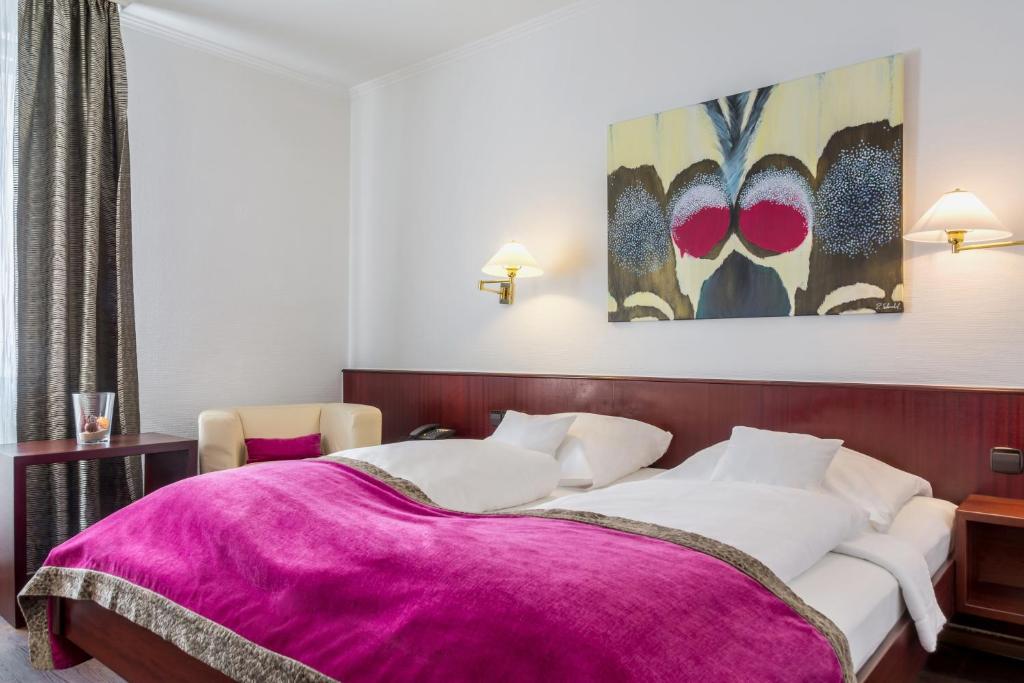 弗莱堡中央公寓酒店的一间卧室配有一张带紫色毯子的床