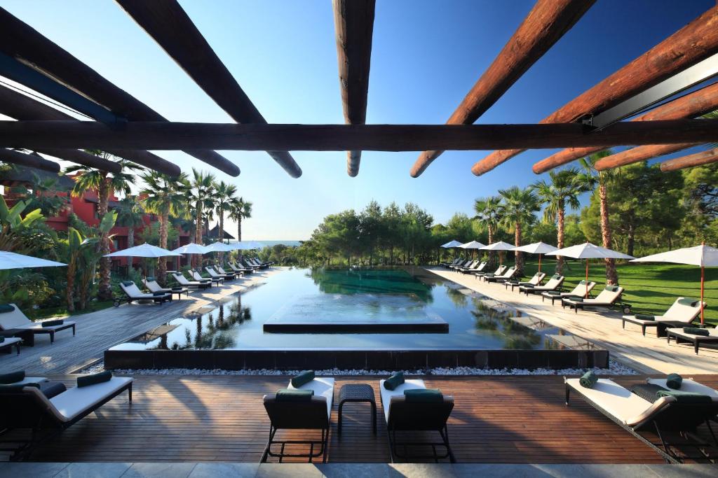 菲内斯特拉特亚洲花园酒店及泰国水疗中心 - 皇家隐居酒店的享有带躺椅的度假村的游泳池景致