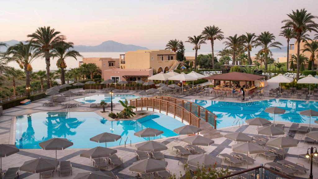 马斯蒂查里海滩地平线度假酒店的享有带椅子和遮阳伞的度假村游泳池的顶部景致