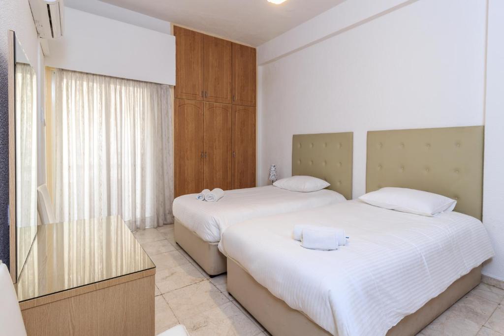 拉纳卡莱斯波米尔公寓的一间卧室配有两张带白色床单的床
