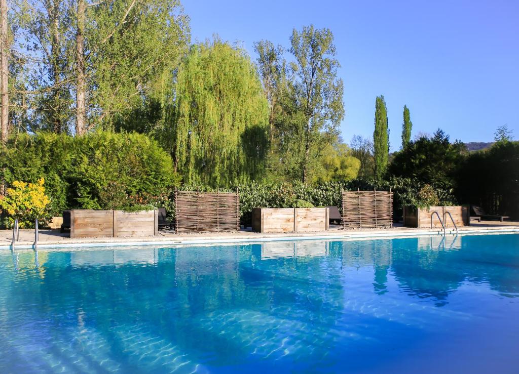 圣塞雷Les Trois Soleils的一个带椅子的游泳池,海水蓝色