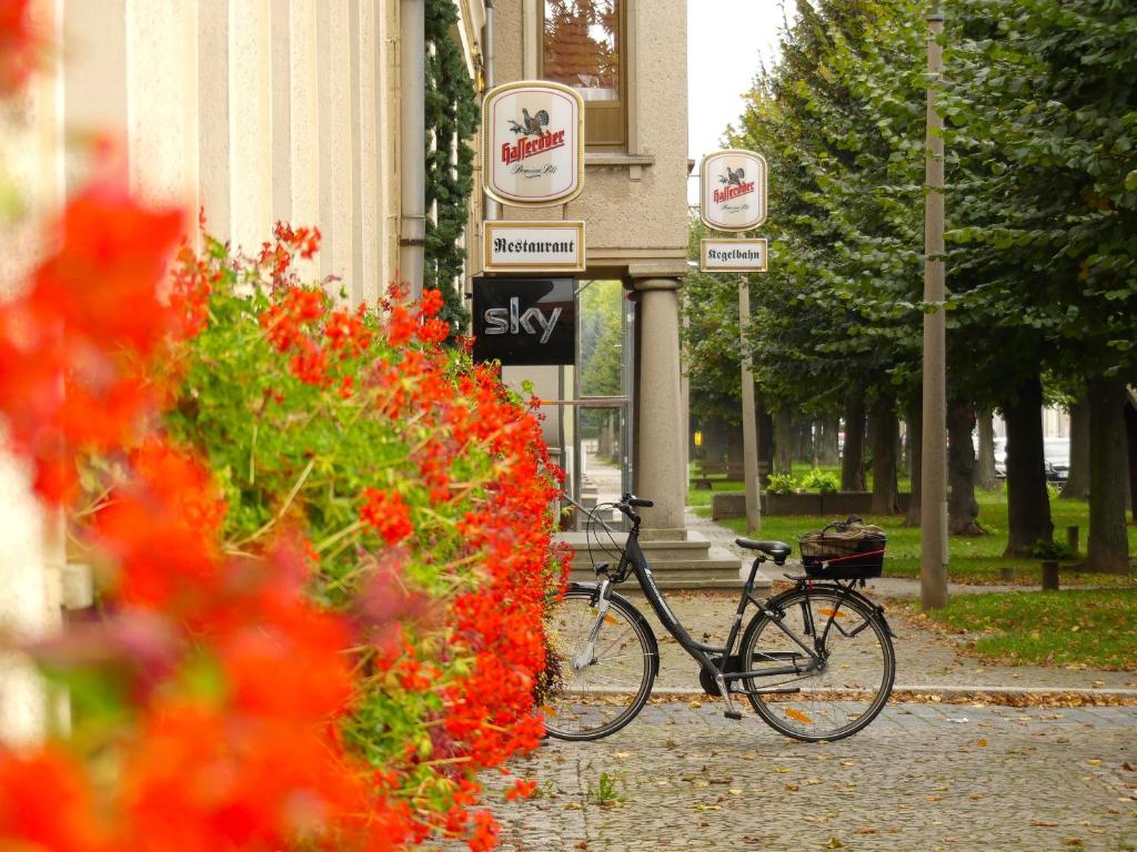 NachterstedtHotel zum Schwan的停在鲜花建筑前面的自行车