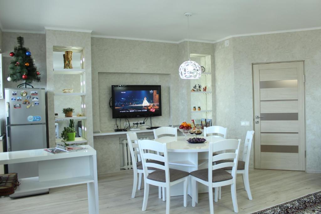 卡拉科尔Apartment in the Karakol heart的厨房以及带白色桌椅的用餐室。