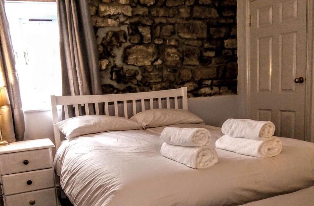 FeltonThe George & Dragon的一间卧室配有带毛巾的床