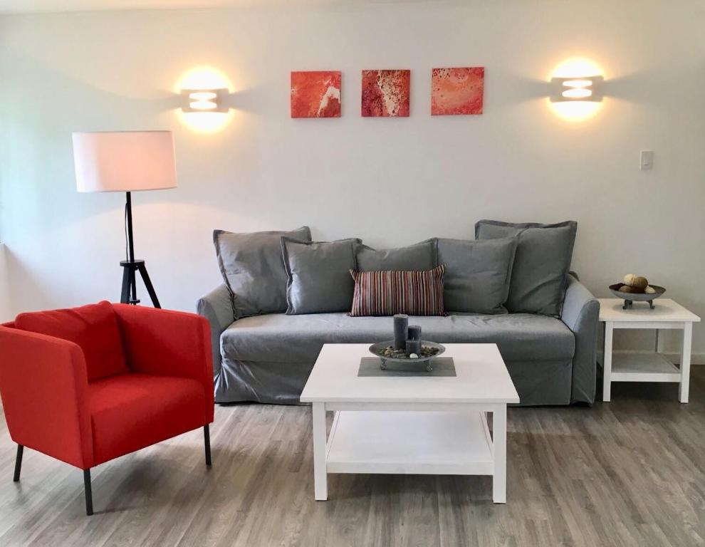 基督教堂市Dover Woods Apartments的带沙发和红色椅子的客厅