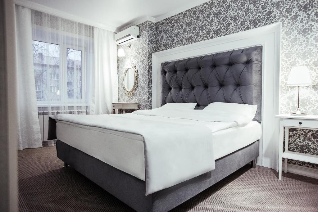 彼得罗巴甫洛夫斯克Skif HOTEL & SPA的一间卧室配有一张大床和大床头板