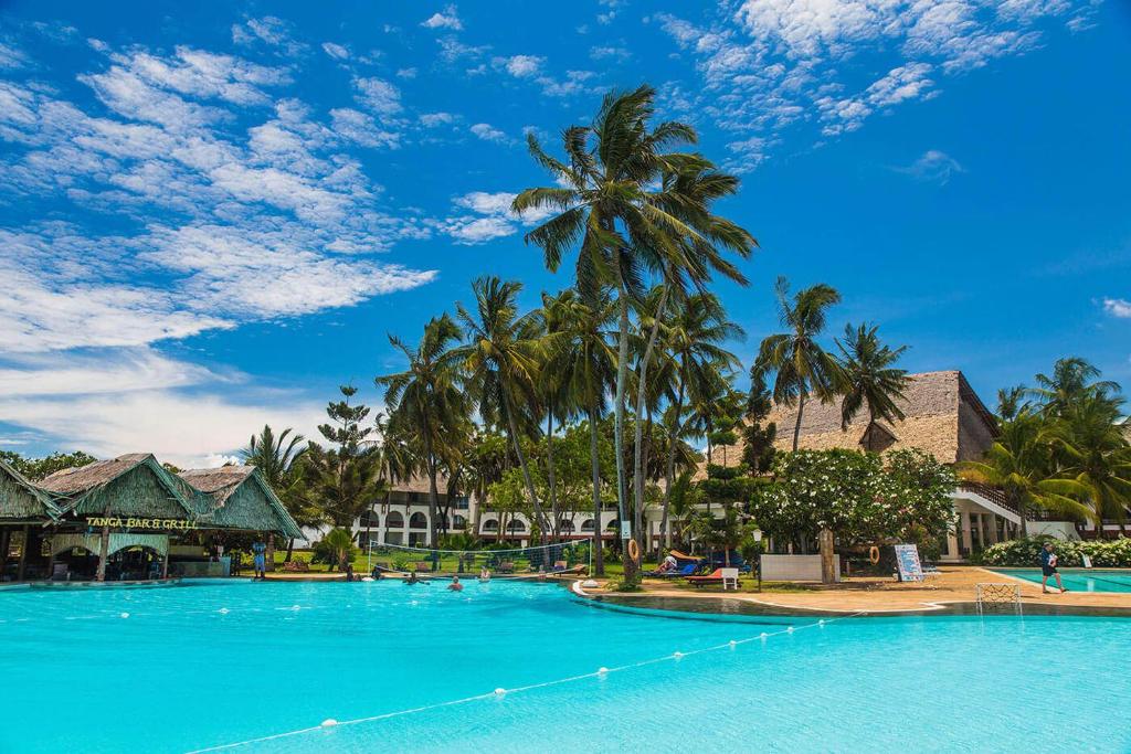 蒙巴萨蒙巴萨里弗酒店的度假村内一座种有棕榈树的大型游泳池