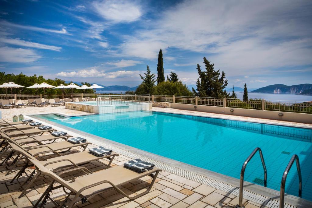 费斯卡尔德宏Almyra Hotel的一个带躺椅的游泳池,一个度假村