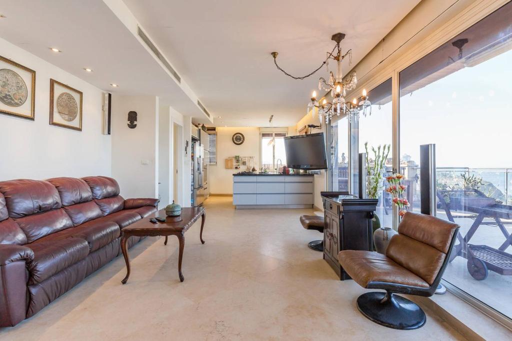 特拉维夫Jaffa Family Penthouse, sea front , 3BR, 2BA,的客厅配有真皮沙发和电视