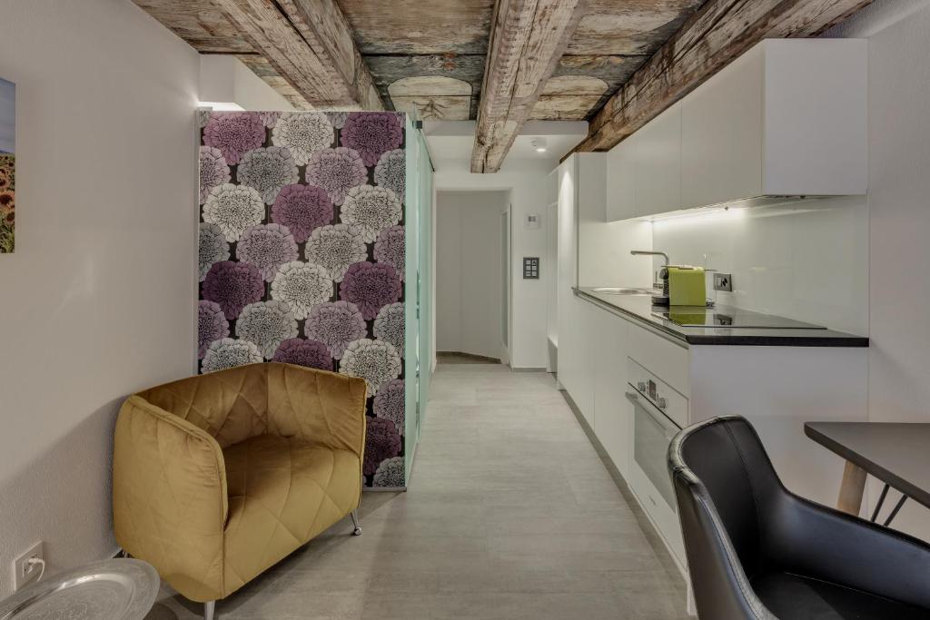 巴登smartroom The Residence la Cittadella Baden的一间带椅子的客厅和一间厨房