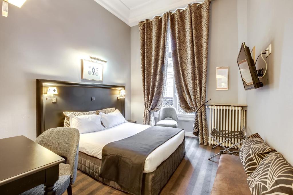 巴黎曼特农歌剧院酒店的配有一张床和一张书桌的酒店客房