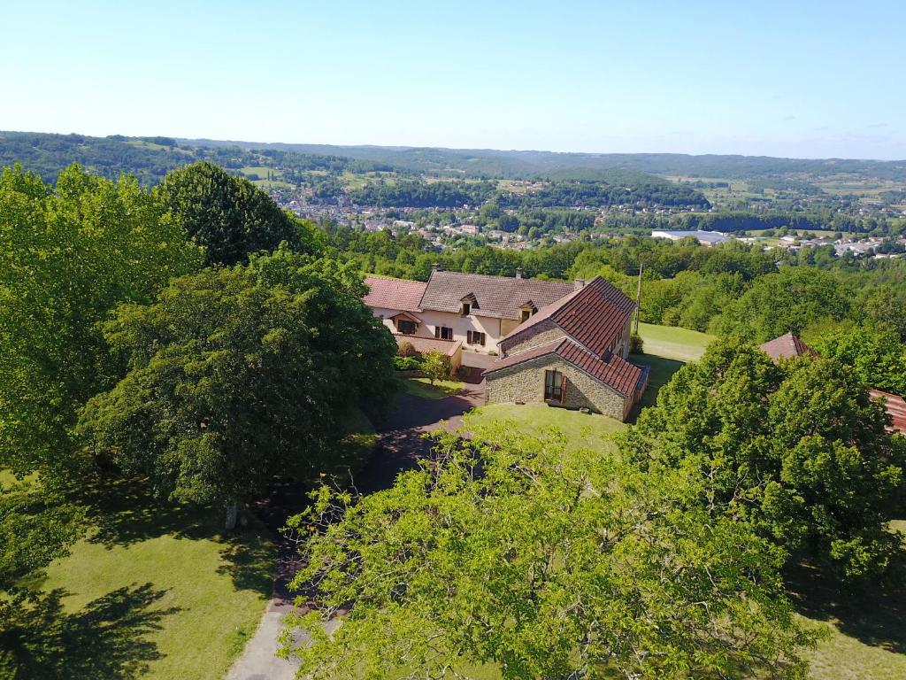 蒙蒂尼亚克Domaine de Lascaux的树木茂密的山丘上房屋的空中景观