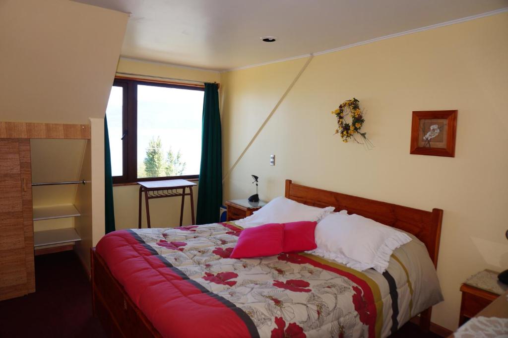 普孔洛杉谷乐思拉坎德拉里亚公寓式酒店的一间卧室配有一张带红色枕头的床