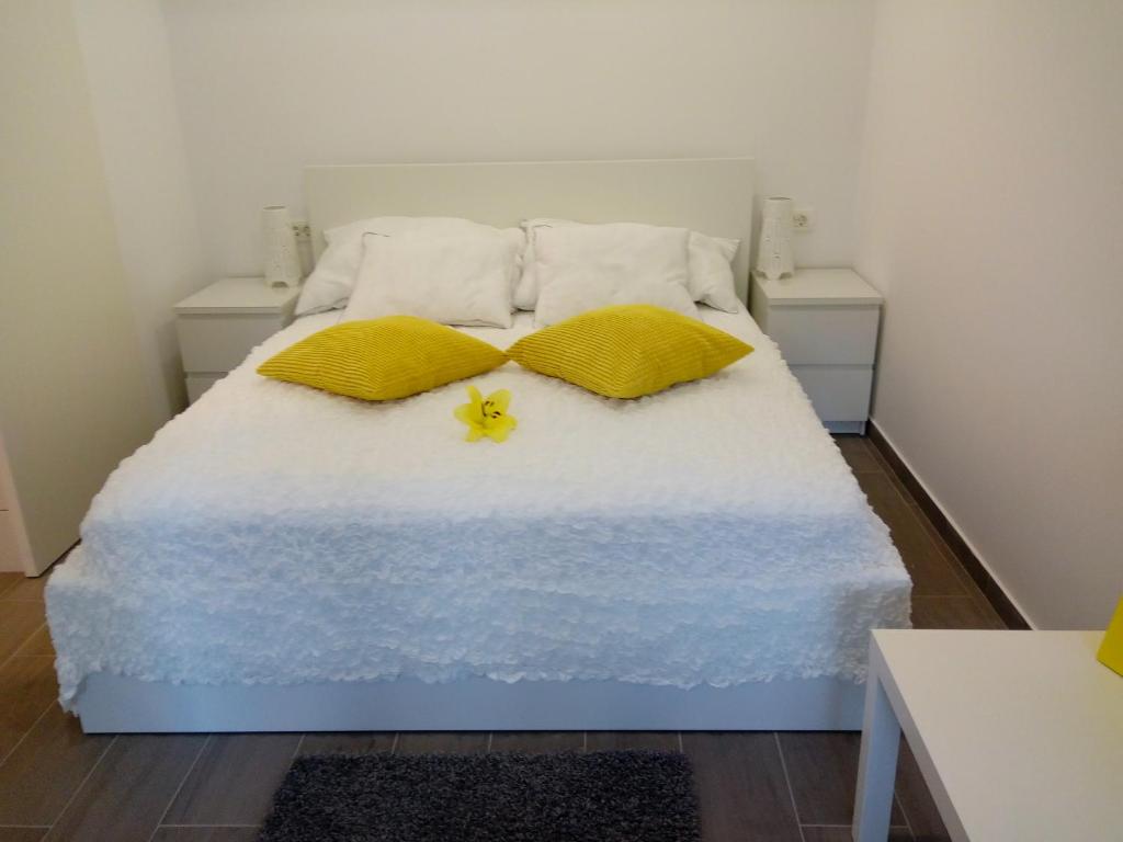 布莱德Apartma Neža的一张带两个枕头的床,上面是黄色的花