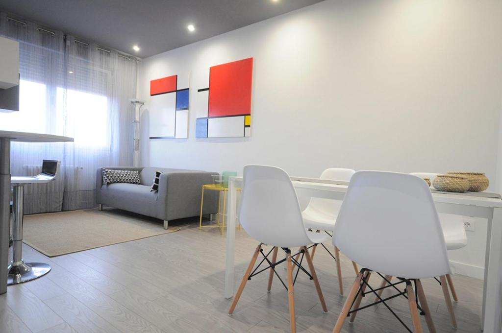 萨莫拉el11 apartamento的客厅配有白色的椅子和桌子
