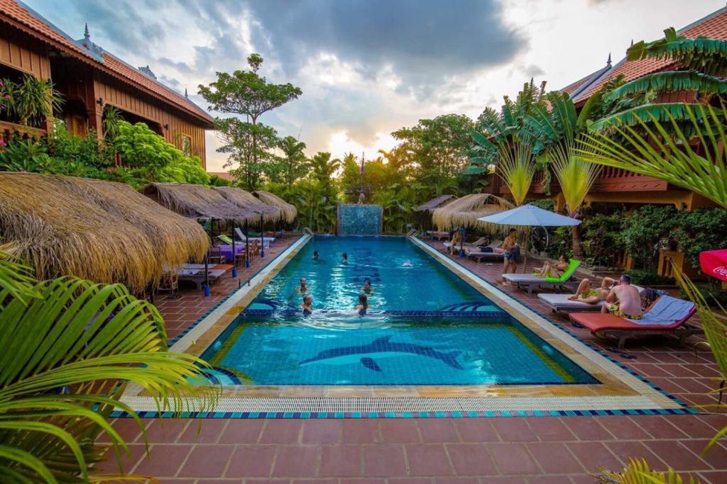 马德望豪华别墅酒店的度假村的游泳池,人们在里面游泳