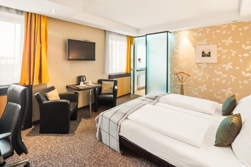 德赖艾希赫罗纳酒店的配有一张床和一张书桌的酒店客房