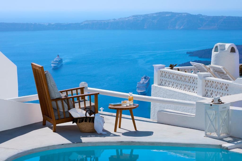易莫洛林杉斯精品酒店的阳台享有海景,配有椅子和游泳池。