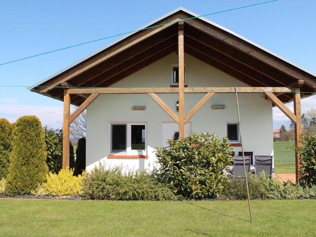 巴斯托夫Sunlit Holiday Home with Fenced Garden in Bastorf的白色的小房子,设有木屋顶
