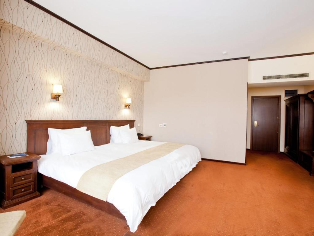布加勒斯特国际布加勒斯特市中心酒店的一间卧室配有一张带白色床单的大床