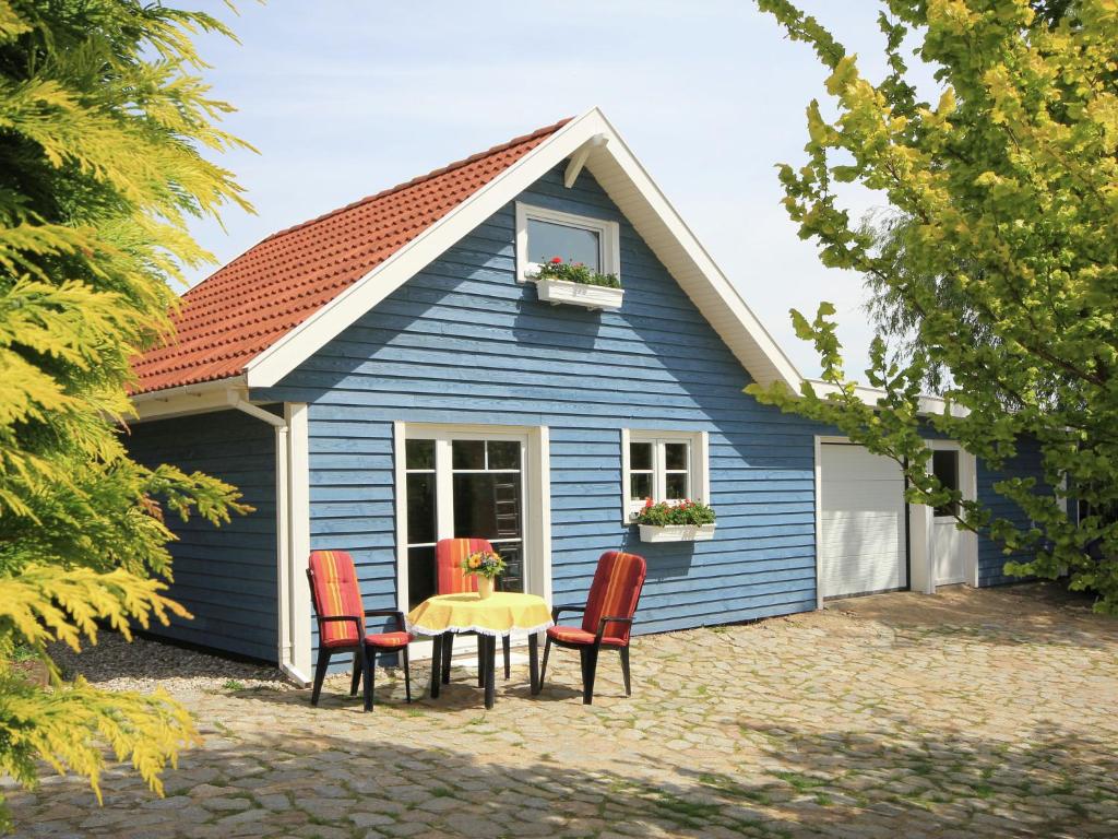 施特芬斯哈根Modern Holiday Home in Steffenshagen with Terrace的蓝色房子前面设有桌椅