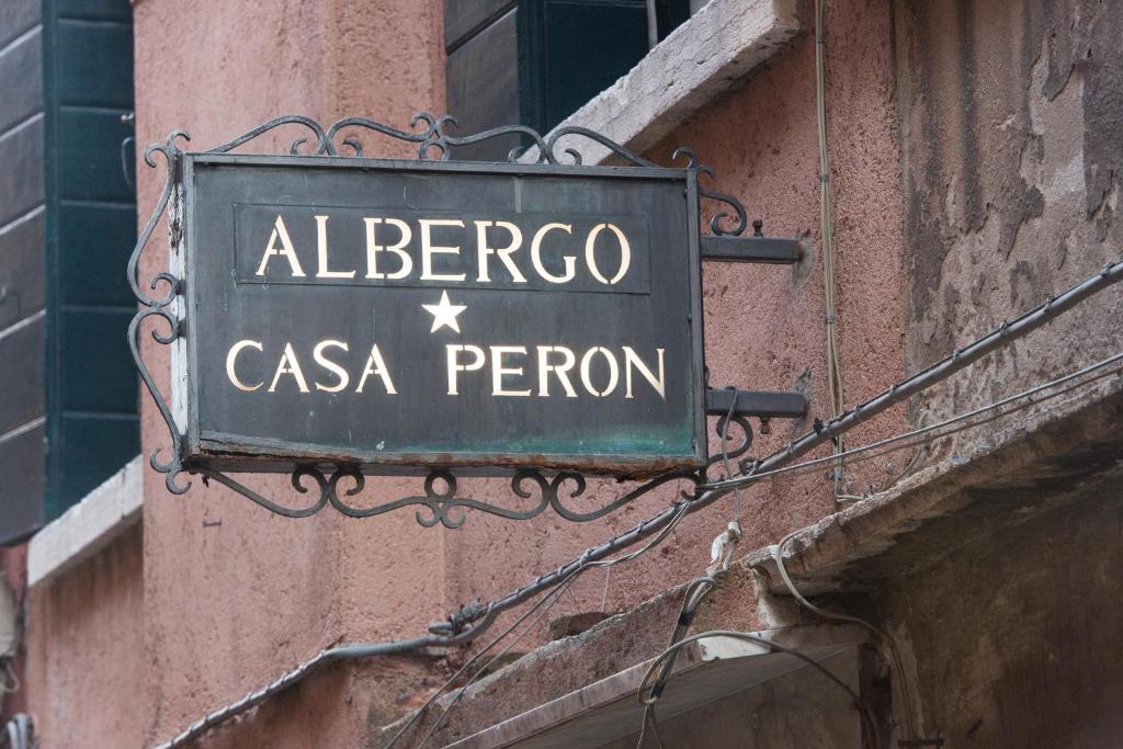 威尼斯阿尔伯格卡萨庇隆酒店的大楼上albergo casa peroni的标志