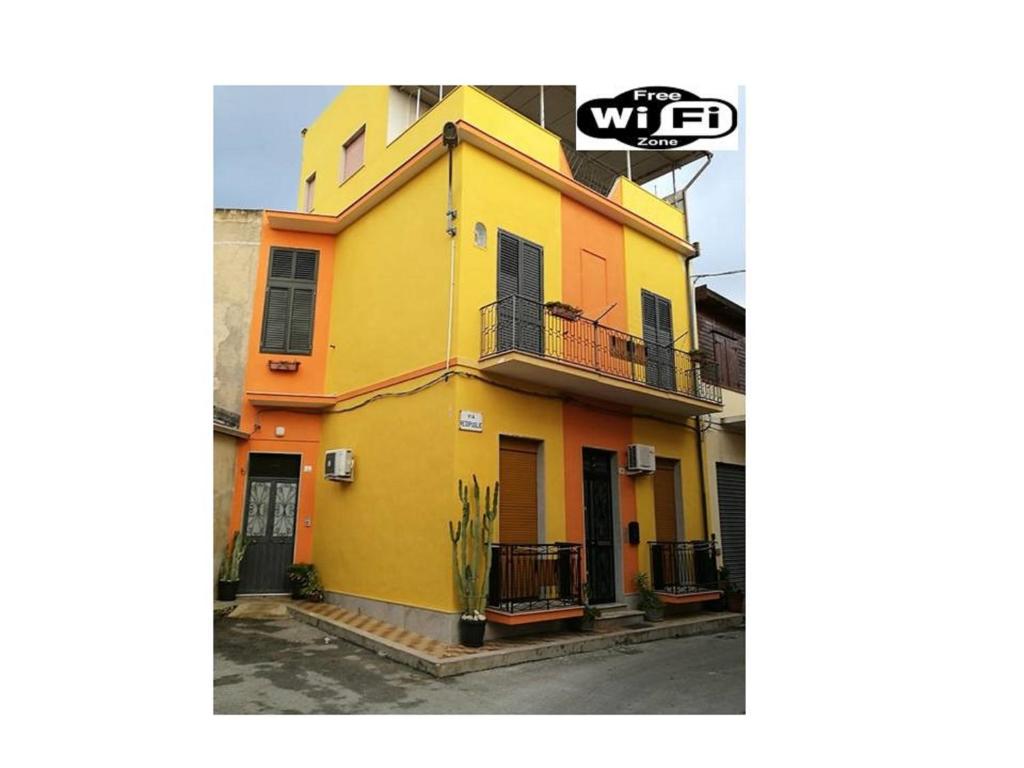 阿沃拉Happy House Wifi Free Bici Free的黄色和橙色的房子设有阳台