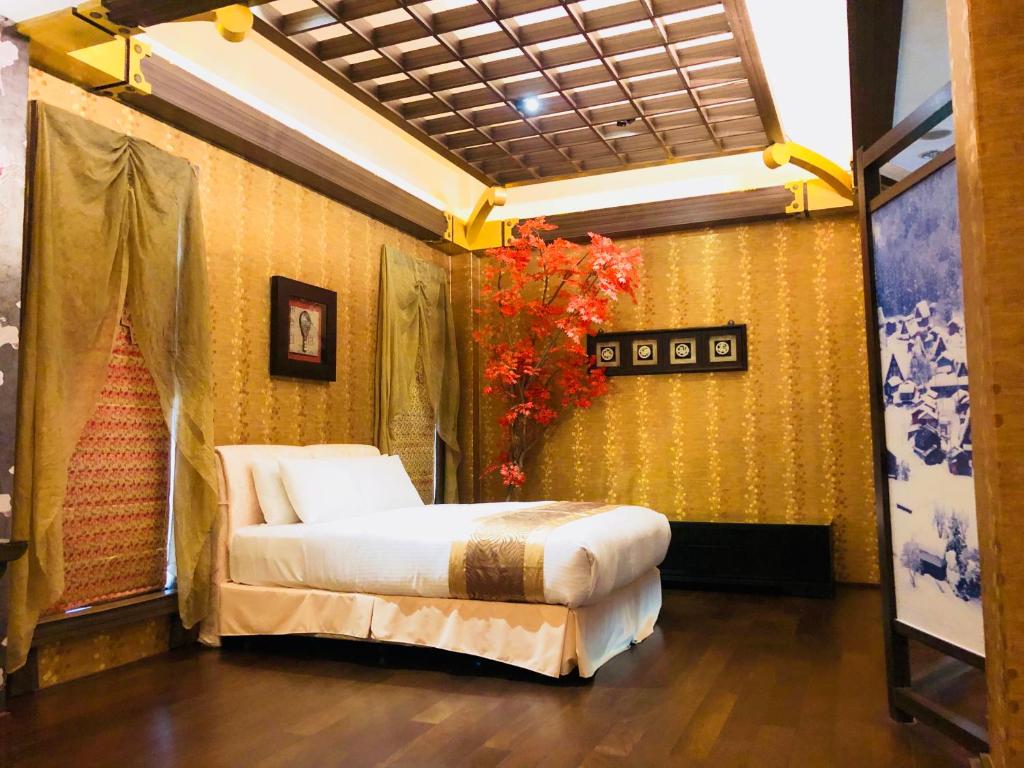 高雄函馆经典汽车旅馆的卧室位于客房的角落,配有一张床